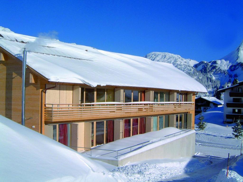 ワースにあるCaroline´s Appartement in Warth am Arlbergの雪屋根の家