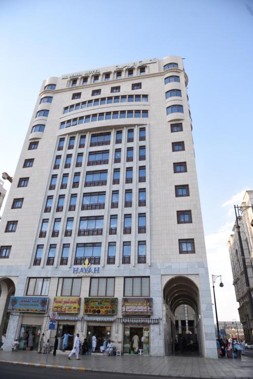 a tall white building on a city street at Hayah Al Waha Hotel in Al Madinah