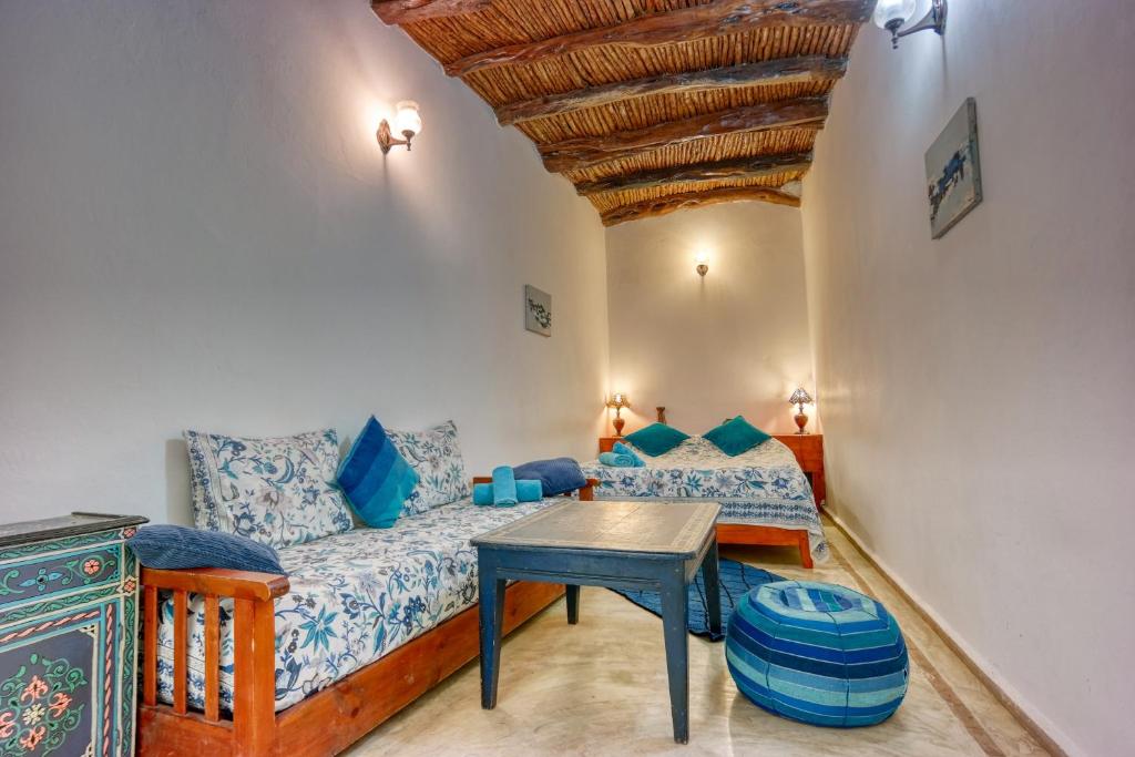 een woonkamer met een bank en een tafel bij Riad Dar Latigeo in Essaouira