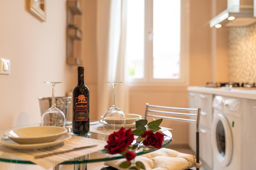Una botella de vino sentada en una mesa en una cocina en Dante Experience Apartment en Florencia