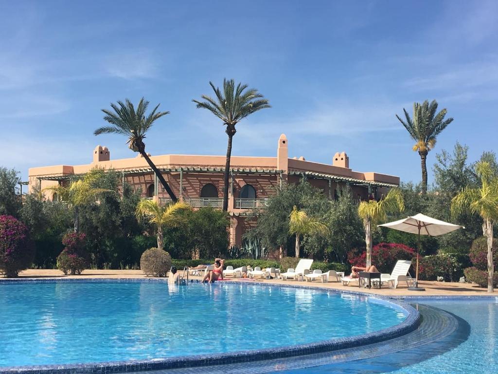 uma pessoa numa piscina em frente a um edifício em Luxury Celine Appart em Marrakech