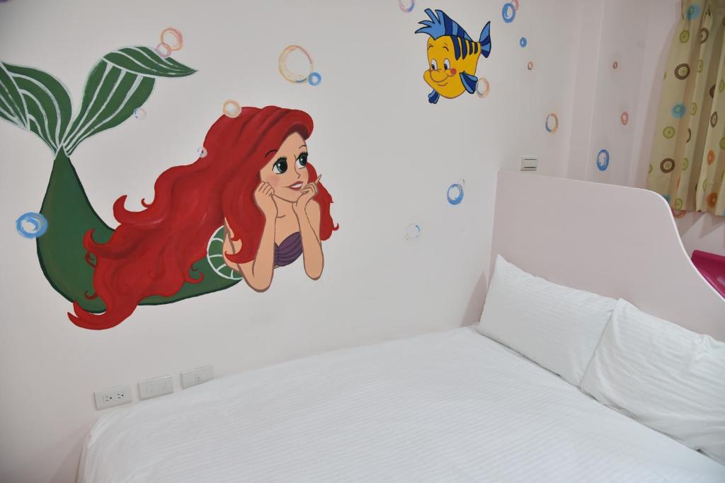 a bedroom with a mermaid decal on the wall at Kids Heart Home in Fengyuan