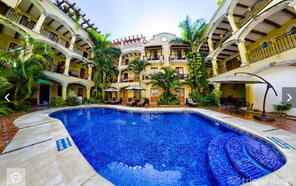 a large swimming pool in front of a building at Hacienda Real del Caribe Hotel in Playa del Carmen