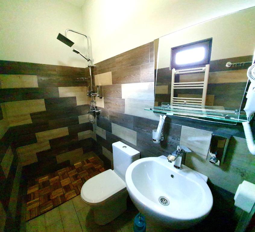un bagno con un water bianco e un lavandino di Hotel Migu Yard a Kazbegi