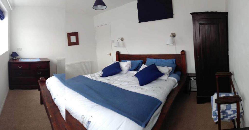 a bed with blue and white sheets and blue pillows at Beach Road in Margate