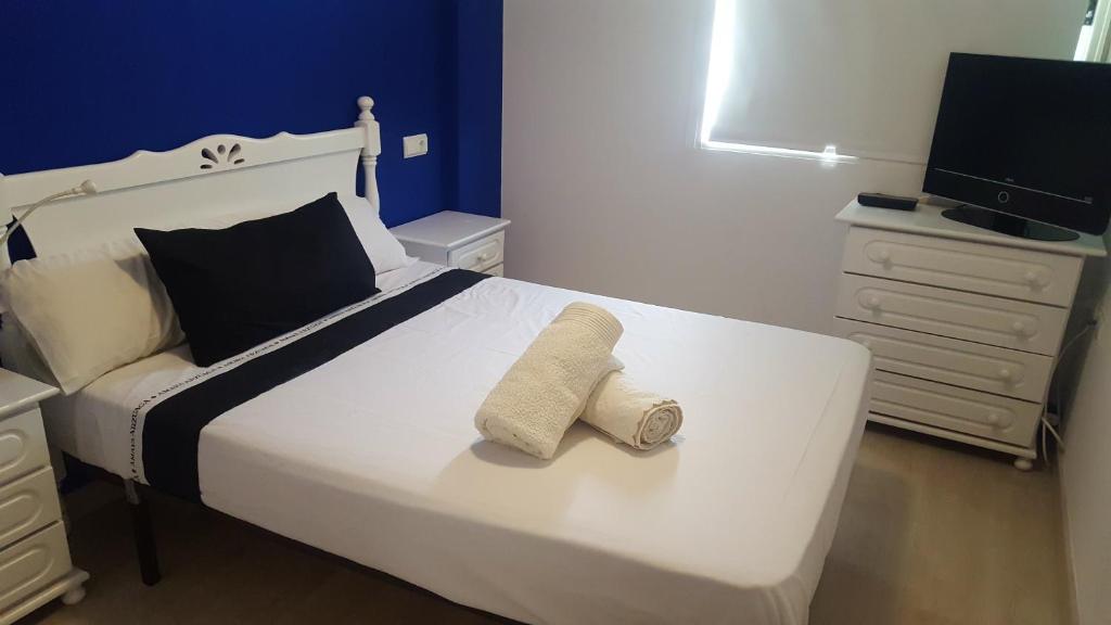 sypialnia z białym łóżkiem i 2 ręcznikami w obiekcie Cabo de Palos apartamento vacacional w mieście Cabo de Palos