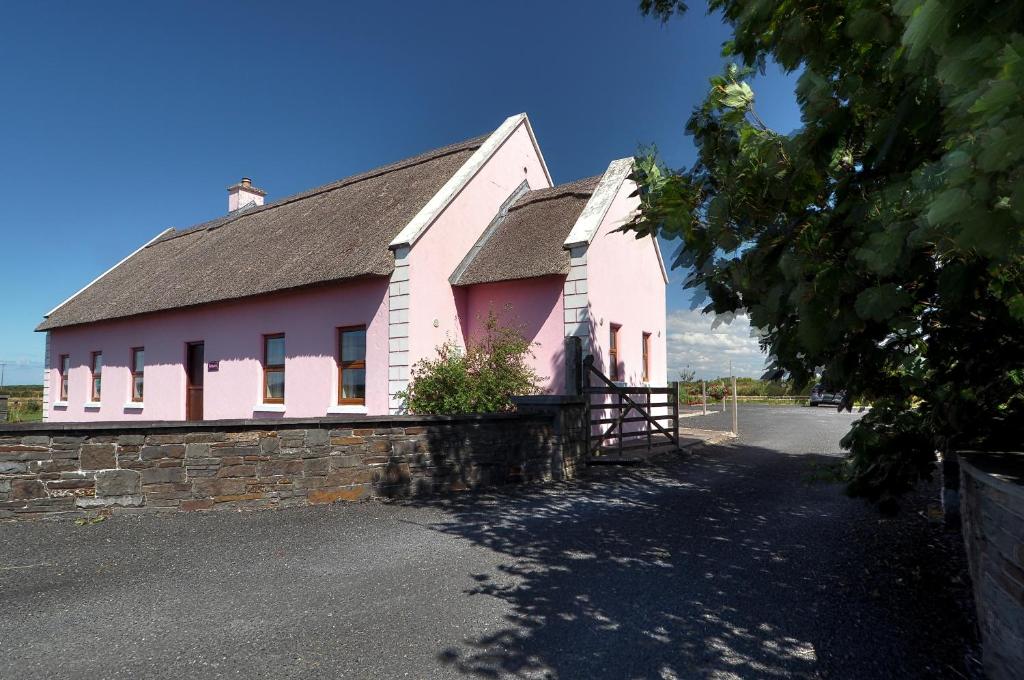 a pink building with a black roof at Behan's Lodge in Doonbeg