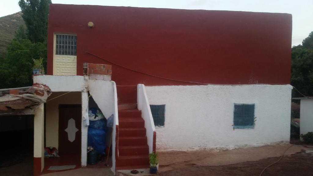 een rood-wit huis met een rood dak bij Auberge de Tabhirte in Tahla
