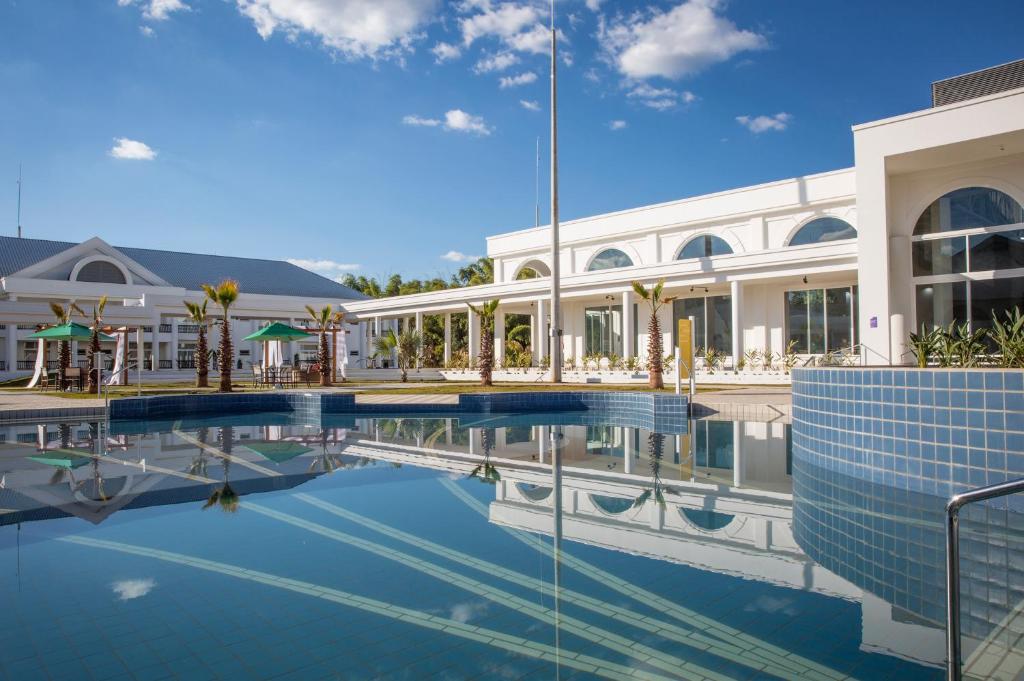 a swimming pool in front of a building at Jardins de Jurema Convention & Termas Resort in Iretama