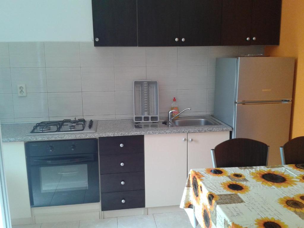 a kitchen with a sink and a stove and a refrigerator at Sea view apartman Antonio in Zadar