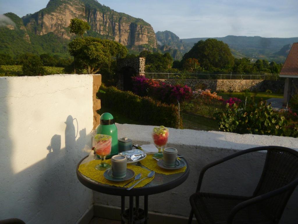 uma pequena mesa com duas bebidas numa varanda em Villa Los Agaves - Hospedería em Tlayacapan