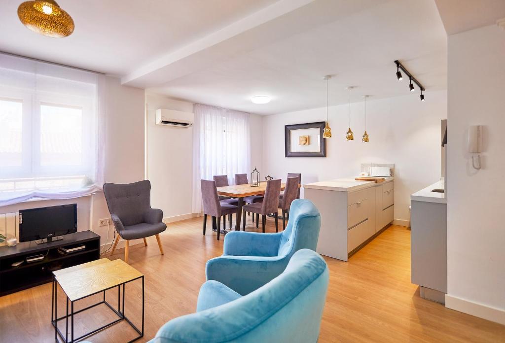 a living room with a blue couch and a table at VUT San Francisco 3 in Salamanca