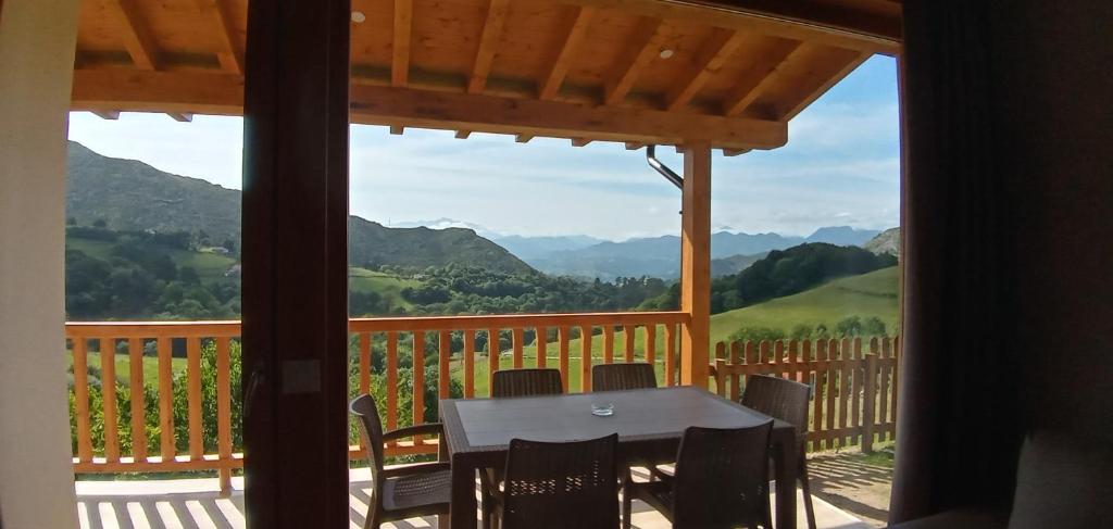 einen Tisch und Stühle auf einer Veranda mit Bergblick in der Unterkunft El Mirador de Bodes in Bodes