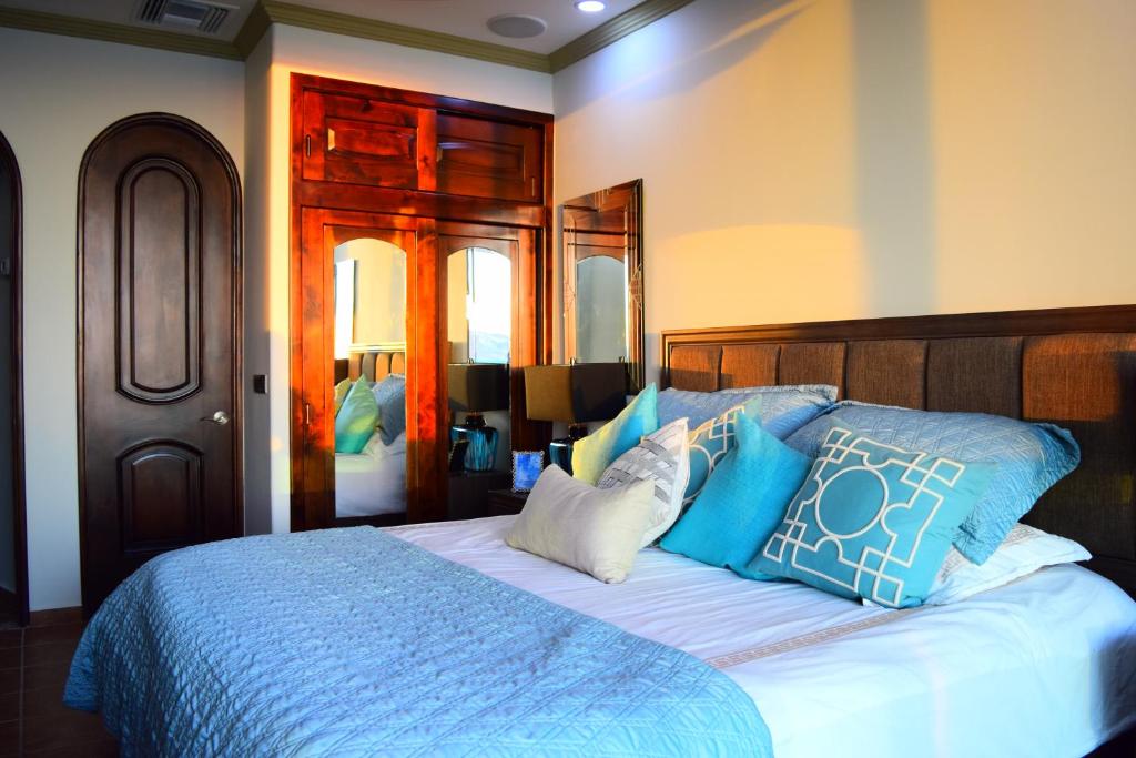 a bedroom with a bed with blue and white pillows at ESMERALDA LUXURY #603B in Puerto Peñasco