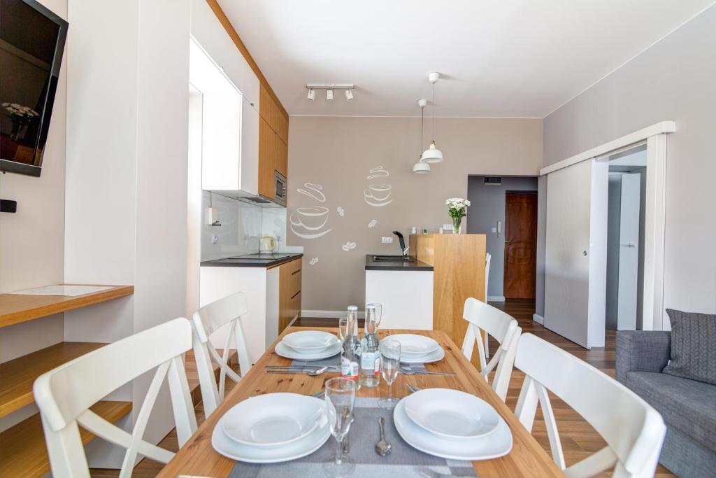 comedor y cocina con mesa y sillas en Krynica Apartamenty Apartament Słoneczny Deptak, en Krynica-Zdrój