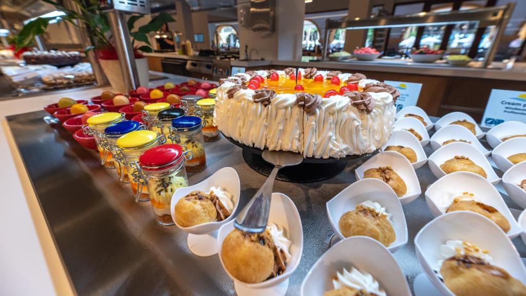 a table with a cake and plates of desserts at TUI Blue Isla Cristina Palace - Adults Recommended in Isla Cristina