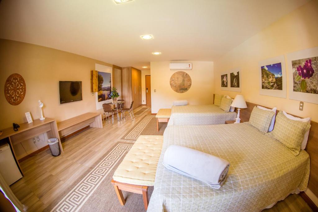 a hotel room with two beds and a television at Haras Morena Resort in Juiz de Fora