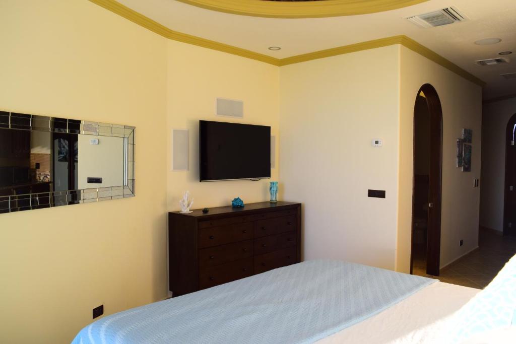 Schlafzimmer mit einem Bett und einem Flachbild-TV in der Unterkunft ESMERALDA LUXURY #203B in Puerto Peñasco