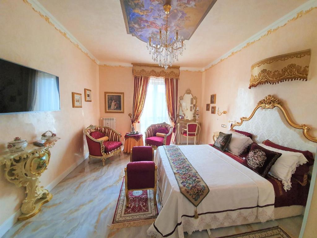 a bedroom with a bed and chairs and a chandelier at FD Luxury rooms in Verona