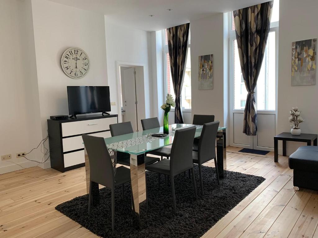 Un comedor con una mesa de cristal y sillas. en Modern Apartment First Floor, en Bruselas