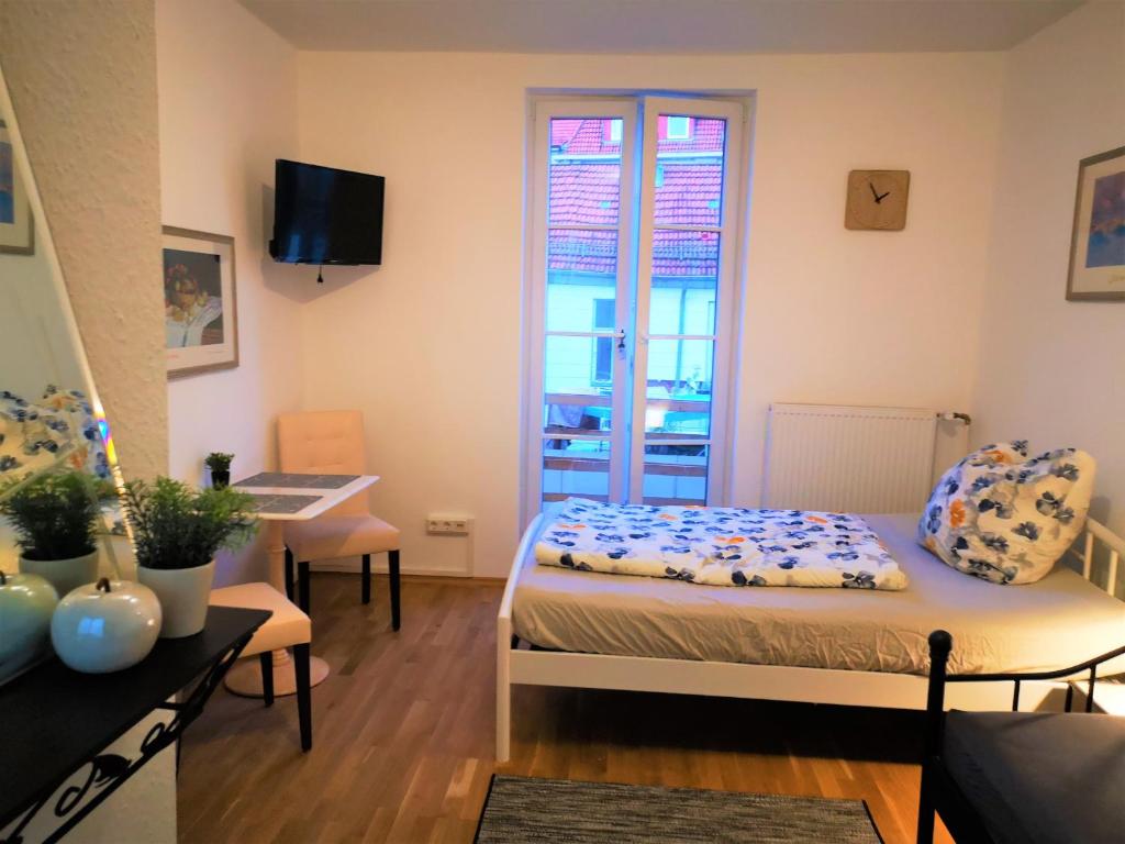 a room with a bed and a desk and a window at City Apartments in Göttingen