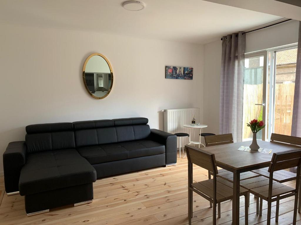 sala de estar con sofá negro y mesa en Attractive modern apartment, en Bruselas