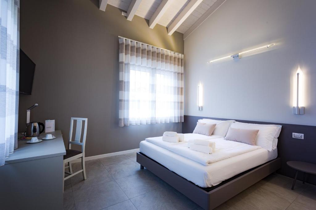 um quarto com uma grande cama branca e uma janela em Borgocinquanta em Isola della Scala
