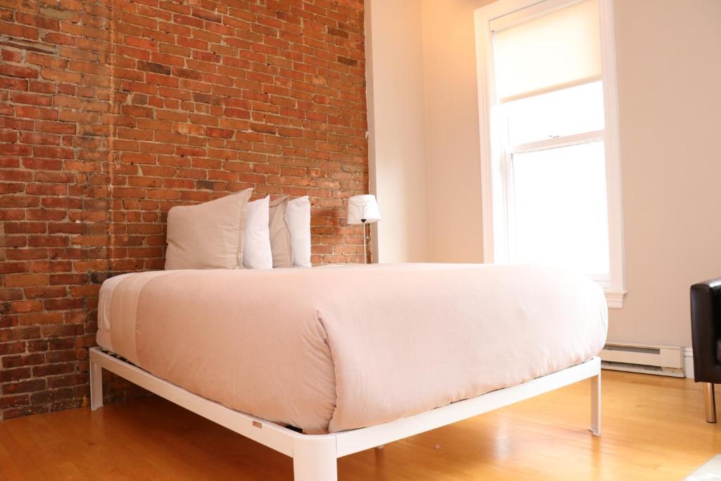 a bed in a room with a brick wall at Charming Studio in Boston Brownstone, #6 in Boston