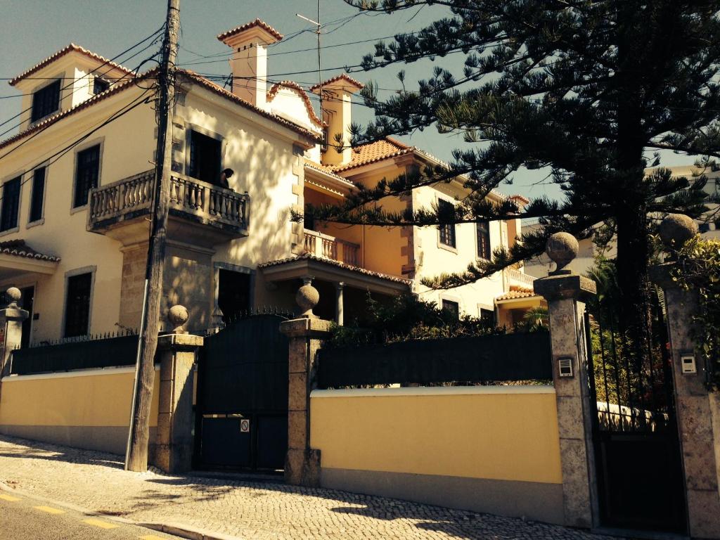 uma casa branca com um portão e uma cerca em Villa Sol Mar - Estoril em Estoril