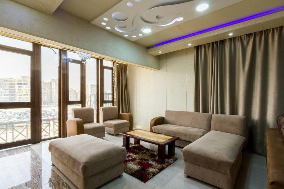 een woonkamer met een bank, stoelen en ramen bij milsa stars 22/1 in Caïro