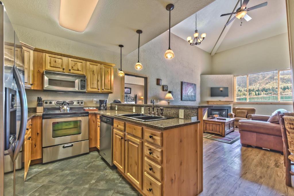 eine Küche mit Holzschränken und Geräten aus Edelstahl in der Unterkunft Steps to skiing, resort property, mountain views, shared hot tub, sauna, steam room 223 in Park City