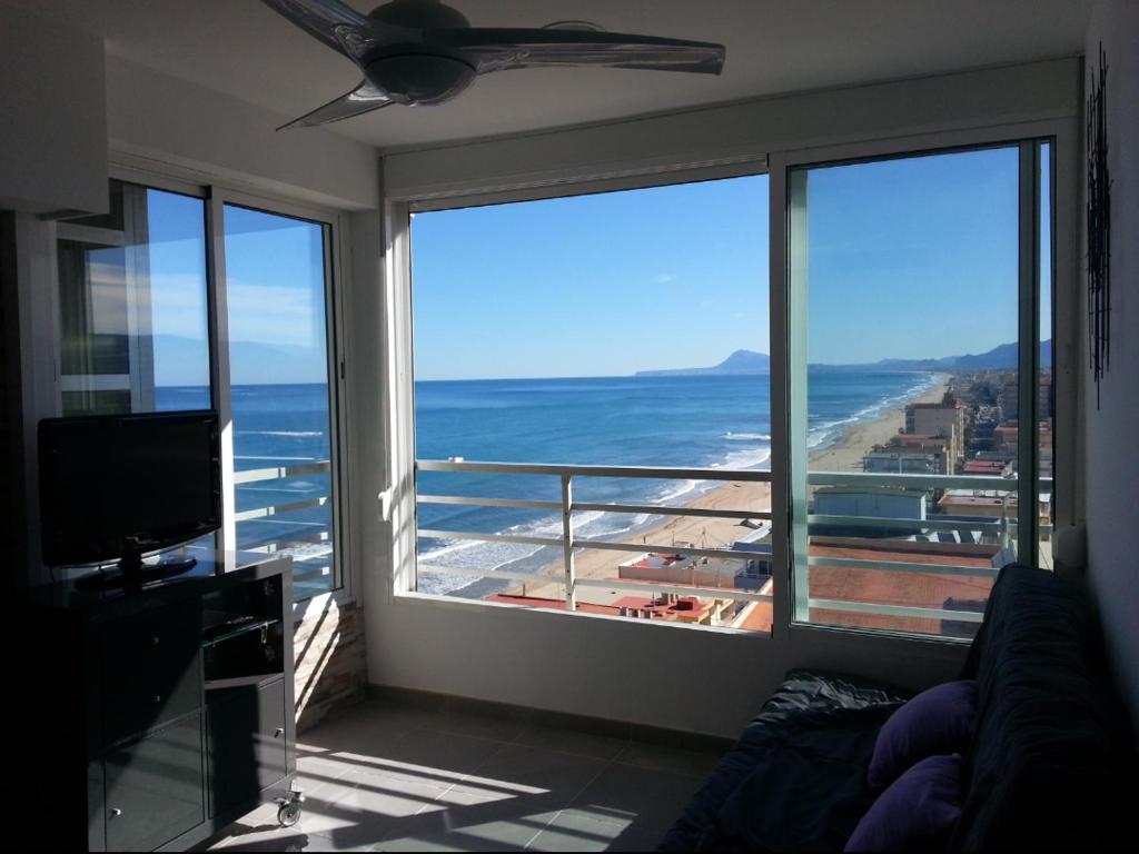 una sala de estar con una gran ventana con vistas al océano en Acogedor apartamento con vistas al mar., en Bellreguart