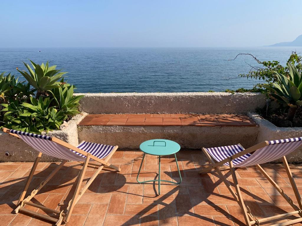 two chairs and a table on a patio overlooking the ocean at Casa delle Galee in Scilla