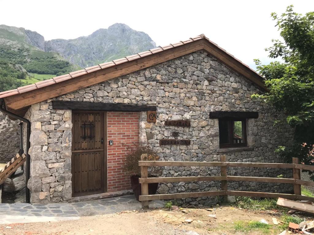 Casa de piedra con puerta de madera y valla en La Cabaña de Bernardina, en Sotres