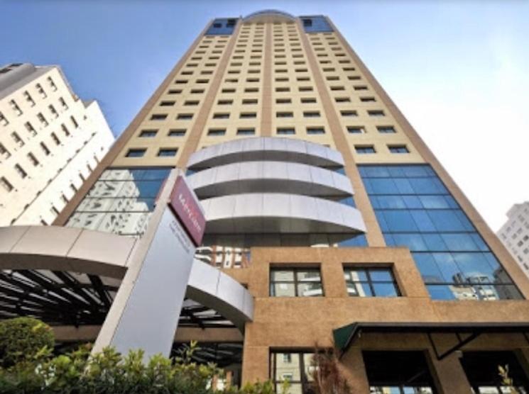 um edifício alto com um sinal em frente em Loft Confortável e Moderno em São Paulo