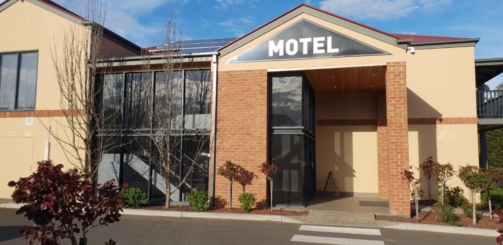 un panneau du motel à l'avant d'un bâtiment dans l'établissement Hogans Motel, à Wallan