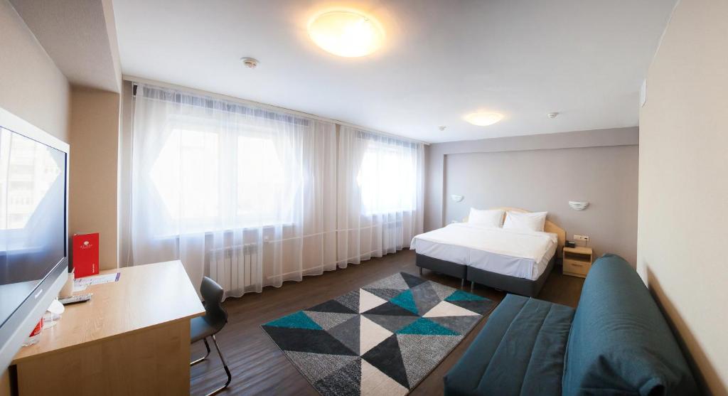 a hotel room with a bed and a couch at AZIMUT Hotel Siberia in Novosibirsk