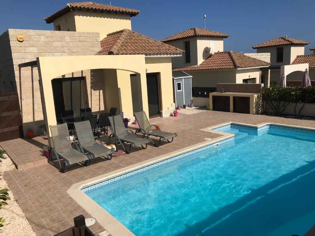 a swimming pool in front of a house at Villa Kallista in Pissouri