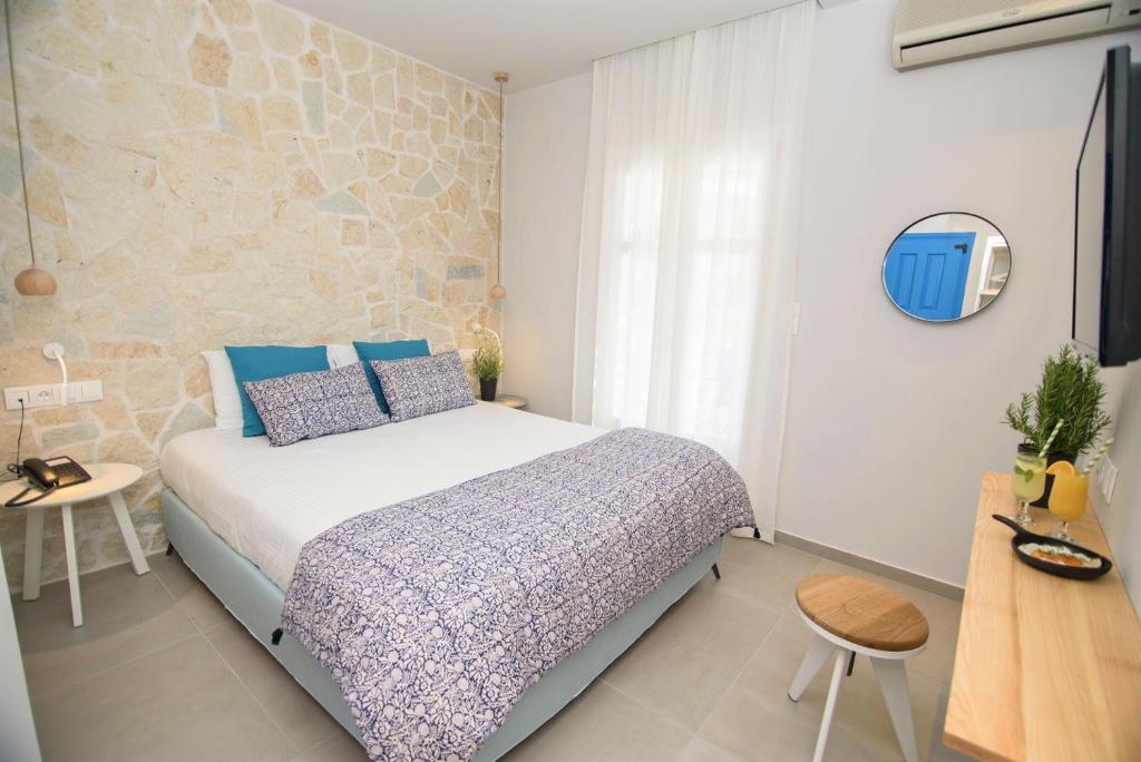 a bedroom with a bed with blue pillows at Vigla Hotel in Aegiali