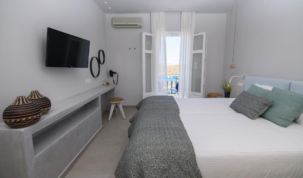 a bedroom with a bed and a tv on a wall at Vigla Hotel in Aegiali