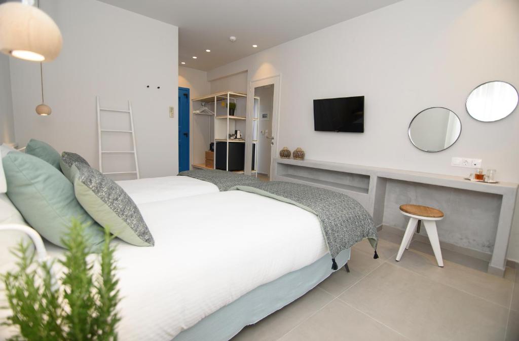 a bedroom with a bed and a desk with a tv at Vigla Hotel in Aegiali
