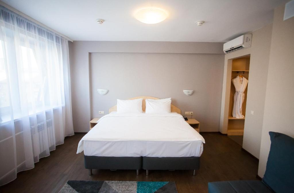 1 dormitorio con 1 cama y 1 vestido en una ventana en AZIMUT Hotel Siberia, en Novosibirsk