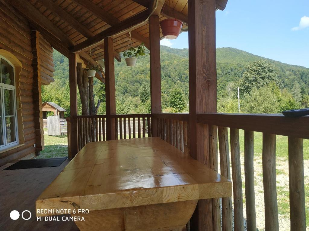 a wooden bench on the front porch of a cabin at Садиба Свидюків in Staryy Mizunʼ