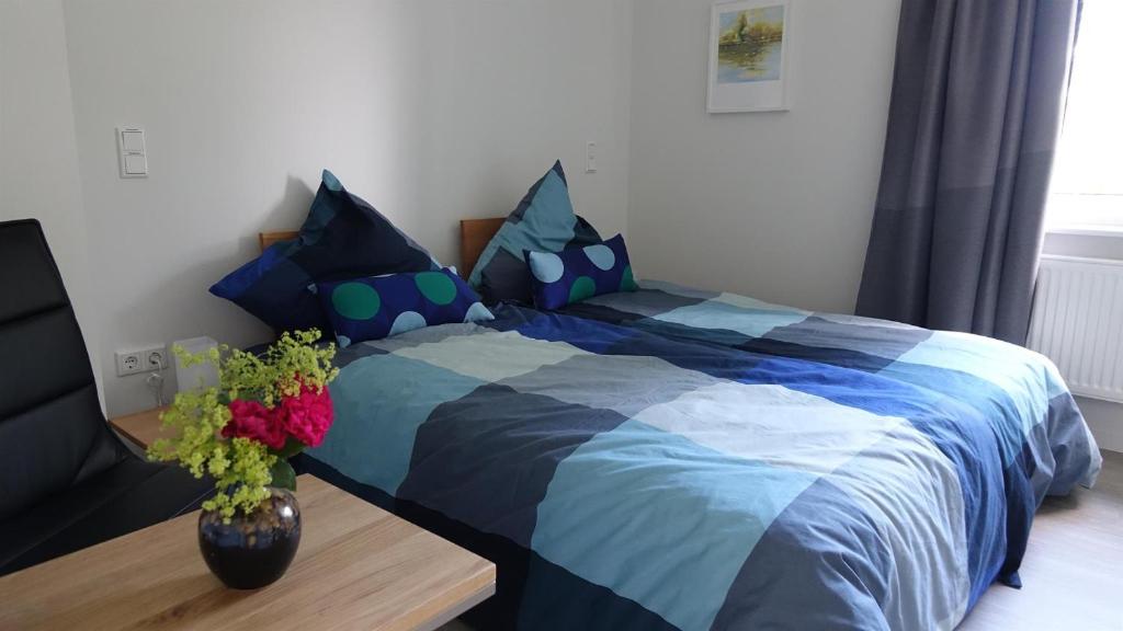 a bed with a blue comforter in a bedroom at Ferienwohnung Tulpenweg in Bad Zwischenahn