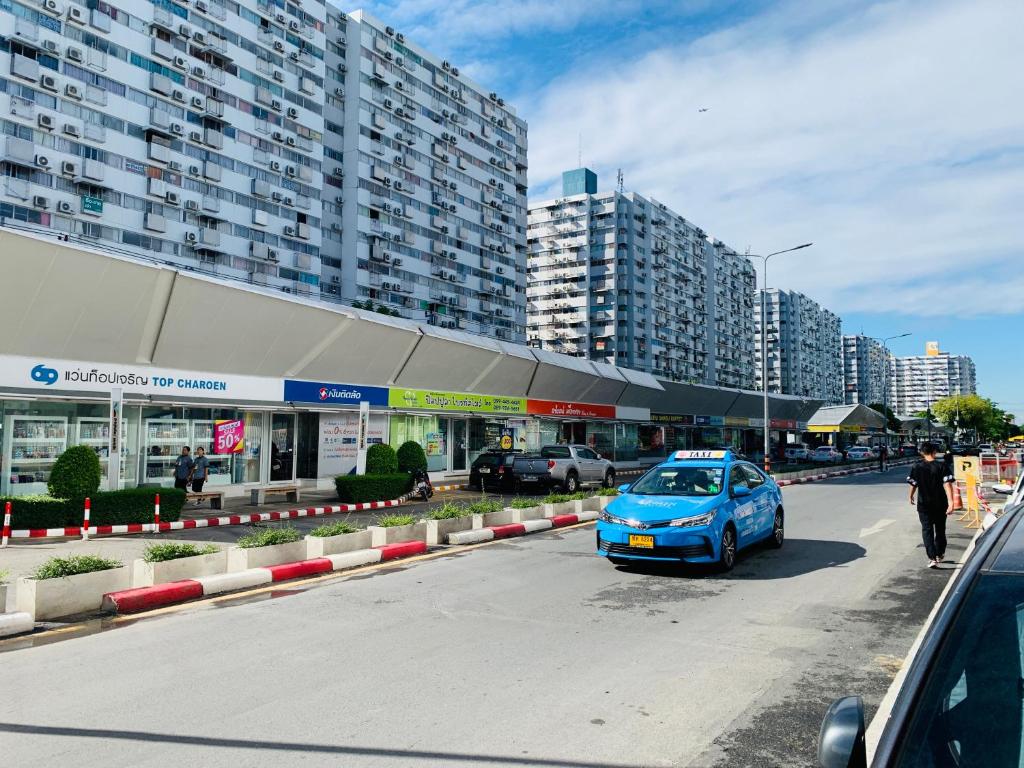 a blue car parked in front of a building at Muangthongthani Rental/Khun Dan in Nonthaburi
