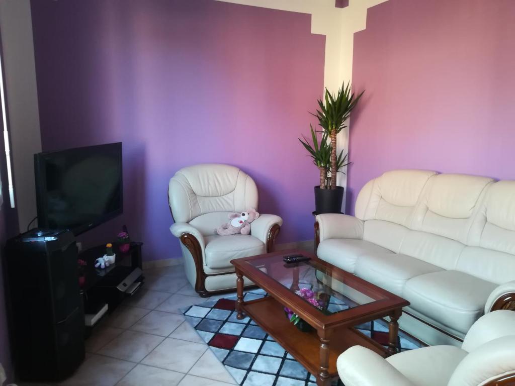 a living room with white furniture and a purple wall at Peace in Corbeil-Essonnes