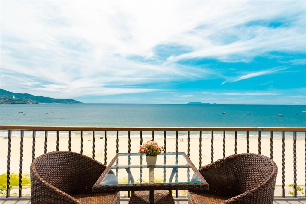 a table and chairs on a balcony with a view of the ocean at Jazz Hotel in Danang
