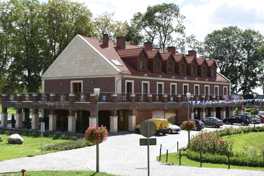 a large brick building with a balcony on top of it at Dom Pracy Twórczej in Uniejow