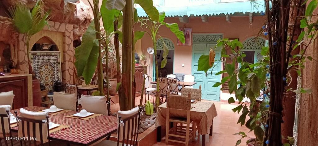 un restaurante con mesas, sillas y plantas en Riad Dar Mchicha by phoenix, en Marrakech