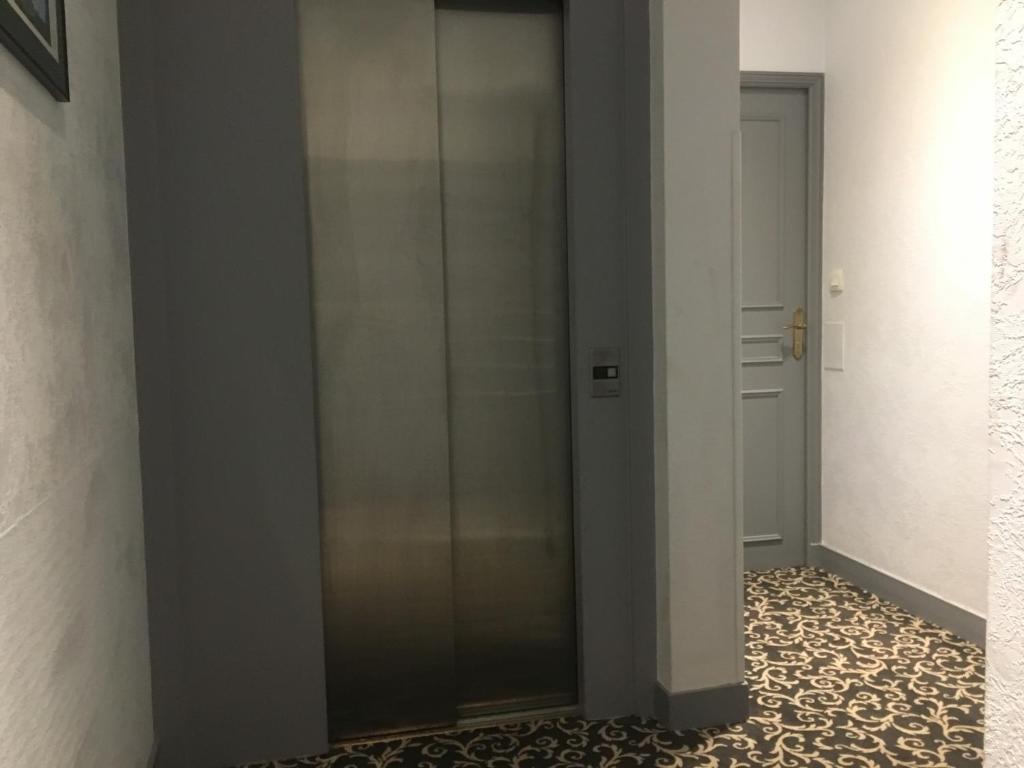 a glass elevator in a hallway with a tile floor at Hotel Mirabeau in Tours